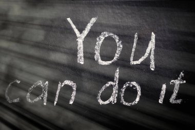 Başarabilirsin. Siyah bir arkaplanda tebeşirle motivasyon yazılımı.