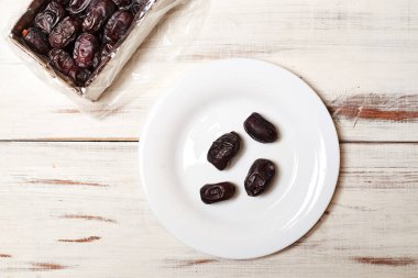 Hafif ahşap arka planda, tabakta tarihler.