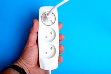 Elektrik uzatma kablosu, priz ve priz mavi arka planda. Elektriklendirme üzerine çalışma kavramı.