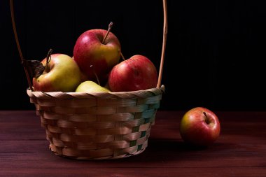 Tahta bir arka planda sepetteki taze elmalar..