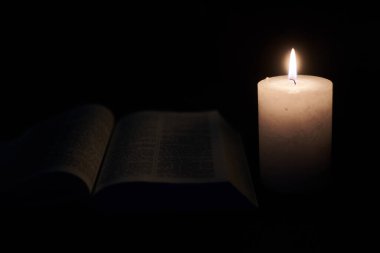 Yakıcı mum ve İncil, kitap. Tanrı 'ya, Hristiyanlığa, dine inanç kavramı.