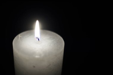 Siyah arkaplanda mum alevi yakın plan.