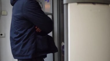 Erkek güvenlik görevlisi manyetik rampanın yanındaki dükkanın girişinde..