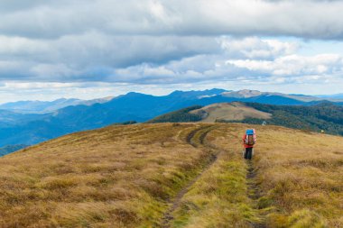 Dağlarda tek bir yürüyüş. Yürüyen bir adamla dağlık arazi manzarası.