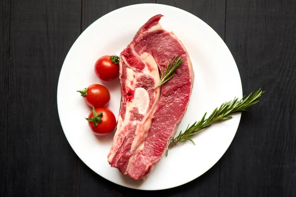 Nyers Borjú Steak Fehér Tányéron Fekete Alapon — Stock Fotó