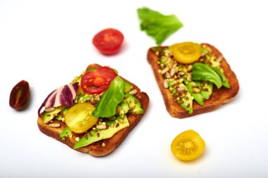 Sebzeli tost, avokado, domates, beyaz arka planda bir dizi tohum. Sağlıklı yemek, diyet konsepti.