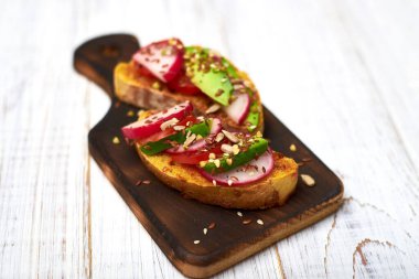 Sebzeli tost, avokado, domates, beyaz arka planda bir dizi tohum. Sağlıklı yemek, diyet konsepti.