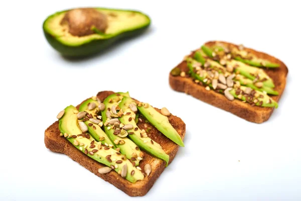 Toast Mit Avocadoscheiben Einer Mischung Aus Samen Auf Weißem Hintergrund — Stockfoto