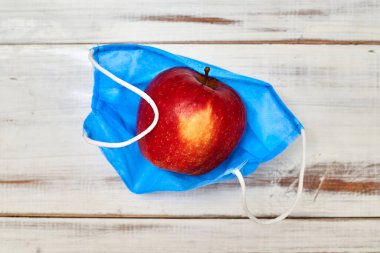 Taze, sağlıklı nefes alma konsepti. Tıbbi maskeli bir elma..