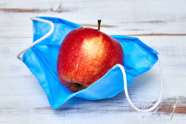 Taze, sağlıklı nefes alma konsepti. Tıbbi maskeli bir elma..