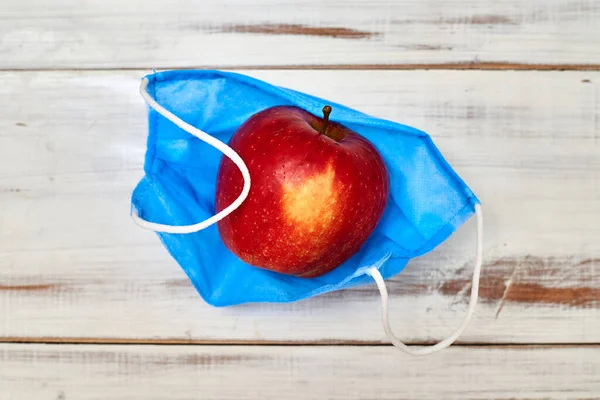 Taze, sağlıklı nefes alma konsepti. Tıbbi maskeli bir elma..