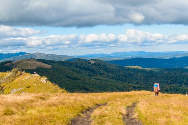 Dağlarda tek bir yürüyüş. Yürüyen bir adamla dağlık arazi manzarası.