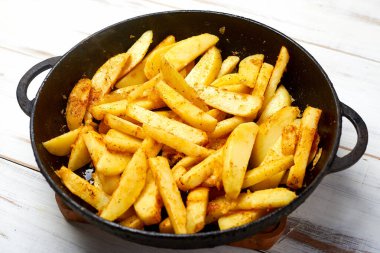 Baharatlı dilimlenmiş patates. Tavada kızarmış patates pişirmek.. 