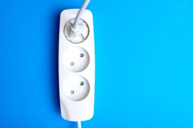 Elektrik uzatma kablosu, priz ve priz mavi arka planda. Elektriklendirme üzerine çalışma kavramı.