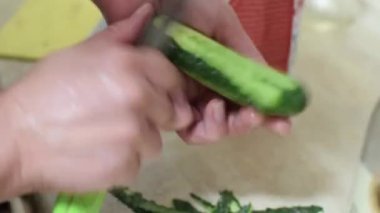 Bir kadın bıçakla salatalık soyuyormuş..