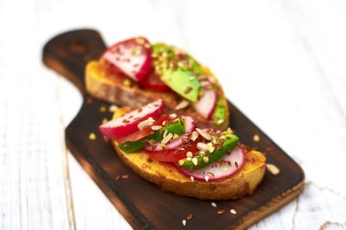 Sebzeli tost, avokado, domates, beyaz arka planda bir dizi tohum. Sağlıklı yemek, diyet konsepti.