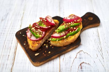 Sebzeli tost, avokado, domates, beyaz arka planda bir dizi tohum. Sağlıklı yemek, diyet konsepti.