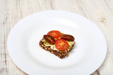 Mısır gevreği ekmeği, krem peynir, avokado ve sebze. Vejetaryen sandviçi.