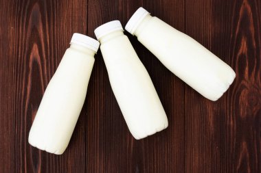 Siyah ahşap arka planda, şişedeki süt..