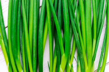 Ahşap zemin üzerinde yeşil soğan kökleri.