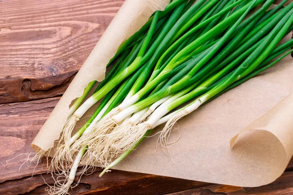 Ahşap zemin üzerinde yeşil soğan kökleri.