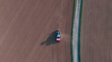 Kırsal alanda traktörün tarla sürüşünü gösteren hava manzarası.