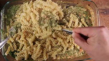 Ev yemeği ve yemek tarifi ilhamı için fırında taze pesto makarnası karıştırıyorum..