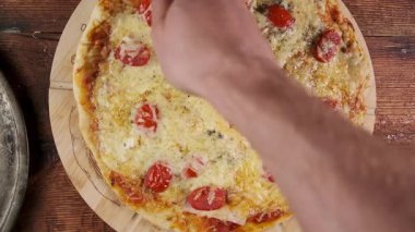 Yeni pişmiş domates ve peynirli pizza dilimliyorum. Mutfak promosyonu için..