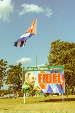 Santa Clara, Cuba-Ocak 6, 2017: Poster görüntü Fidel Castro ve Santa Clara, Küba'da Devrim Meydanı'nda Küba bayrağı ile. Vintage ve yesteryear etkisi ile görüntü