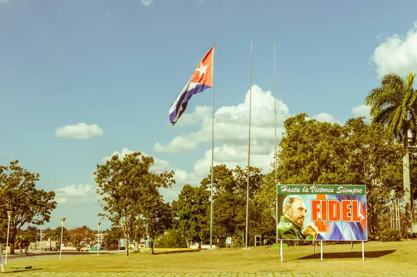 Santa Clara, Cuba-Ocak 6, 2017: Poster görüntü Fidel Castro ve Santa Clara, Küba'da Devrim Meydanı'nda Küba bayrağı ile. Vintage ve yesteryear etkisi ile görüntü