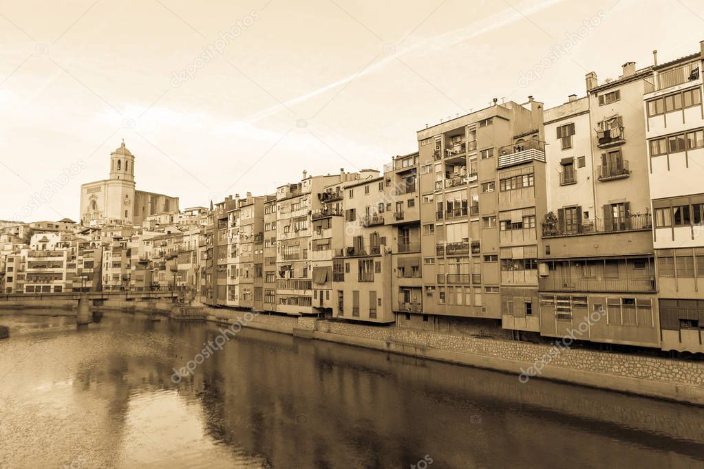 Onyar river crossing the downtown of Girona with bell tower of Basilica of Sant Feliu in background. Gerona, Costa Brava, Catalonia, Spain.