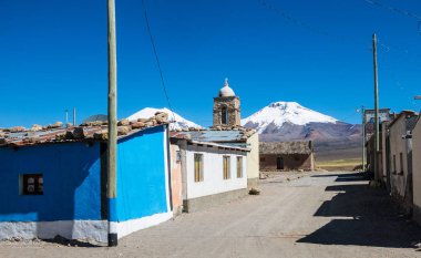 Arka planda Sajama volkanı olan küçük bir And kasabası Sajama. Bolivya Altiplano 'su. Ana ekonomik faaliyeti lama otlatma ve dağ turizmidir. Güney Amerika