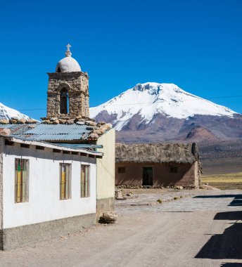 Arka planda Sajama volkanı olan küçük bir And kasabası Sajama. Bolivya Altiplano 'su. Ana ekonomik faaliyeti lama otlatma ve dağ turizmidir. Güney Amerika