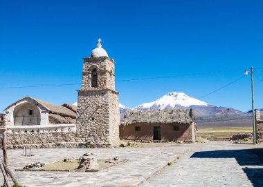 Arka planda Sajama volkanı olan küçük bir And kasabası Sajama. Bolivya Altiplano 'su. Ana ekonomik faaliyeti lama otlatma ve dağ turizmidir. Güney Amerika