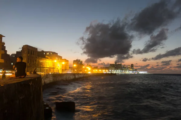 Cubanen overwegen de zonsondergang in de beroemde malecon in Havana, C — Stockfoto