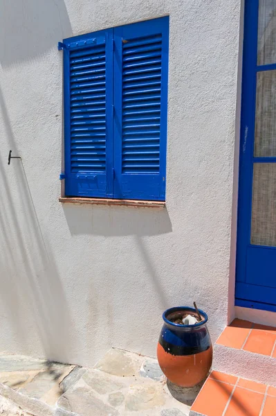 Typical white Mediterranean house, with blue door, in the villag