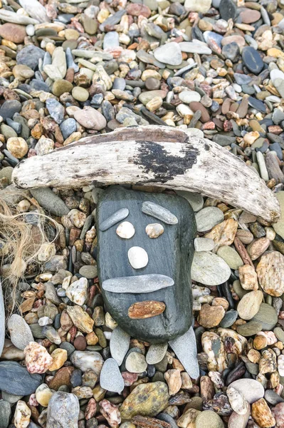 Simpatic gezicht gemaakt op een strand met stenen en kleine houten St — Stockfoto