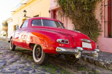 Kırmızı otomobil parke taşlı caddelerinden birinde, şehirde