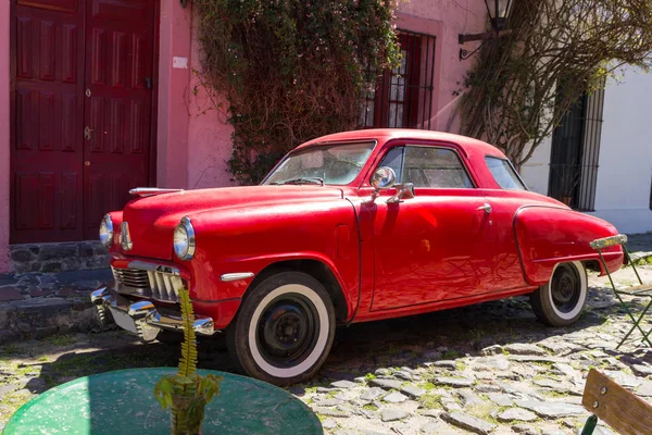 Red automobile on one of the cobblestone streets, in the city of — Stock Photo, Image