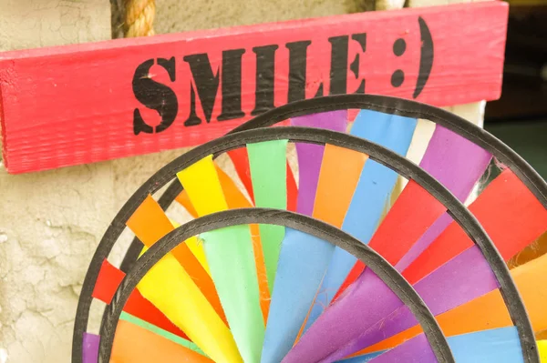 用微笑这个词签名。微笑总是好的，即使一个满是色彩的标牌告诉你 — 图库照片