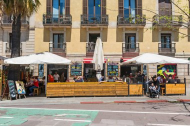 Tourists eat and drink on a terrace in the maritime district of Barceloneta. In Spain these bars are called beach bars. Spain