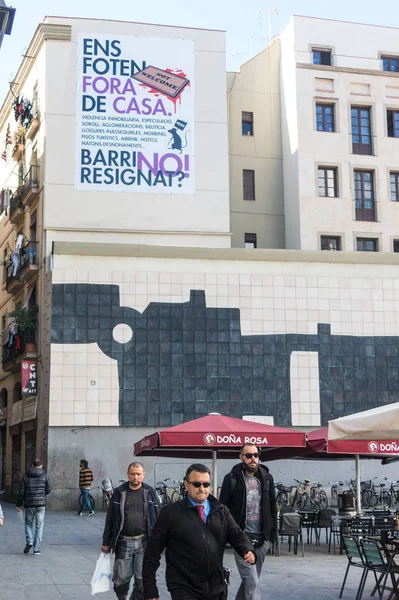 Caminhantes na praça de Los Angeles, centro do bairro Raval em Barcelona, muito perto do Museu Macba. Na parede um mosaico do artista Chillida . — Fotografia de Stock
