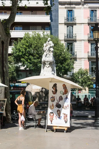 Uliczny malarz karykaturystyczny pracujący przy ulicy La Rambla. Las Ramblas jest jedną z najsłynniejszych ulic w mieście — Zdjęcie stockowe