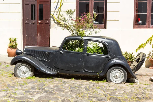 Black and obsolete car on one of the cobblestone streets, in the — Stock Photo, Image