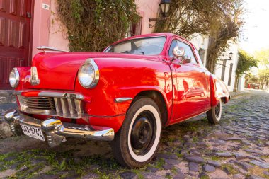 Kırmızı otomobil parke taşlı caddelerinden birinde, şehirde