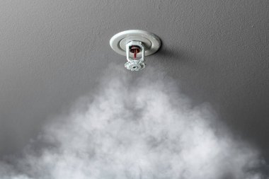 fire alarm sprinkler system in action with smoke clipart