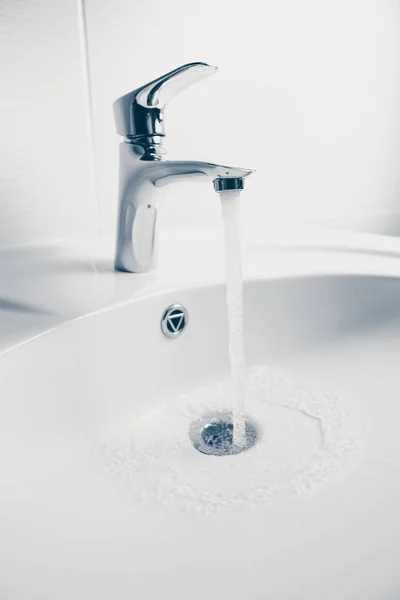 蛇口と洗面シンクの水の流れ — ストック写真
