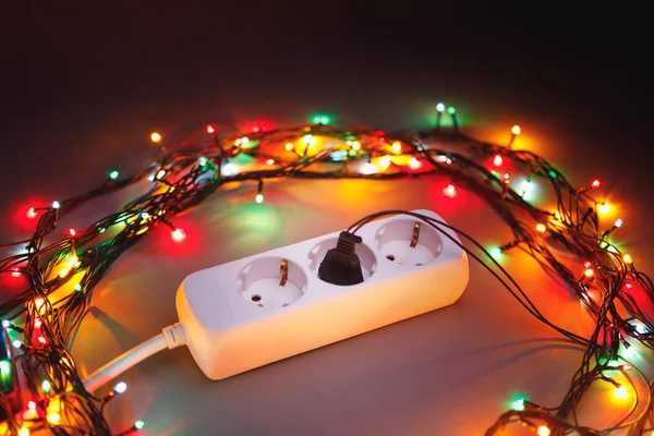 圣诞花环灯围绕电源延长线旋转 — 图库照片