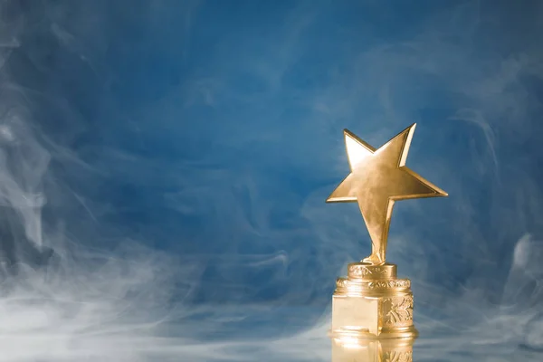 Troféu Estrela Ouro Fumaça Fundo Azul — Fotografia de Stock