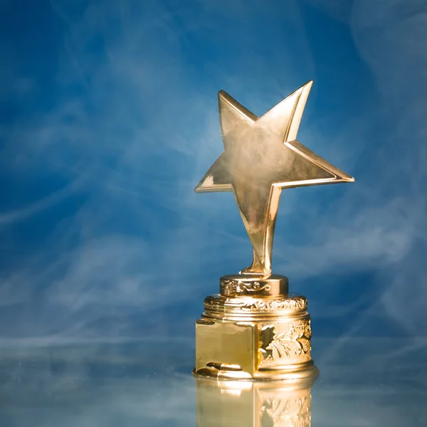 Trofeo Estrella Oro Humo Fondo Azul — Foto de Stock